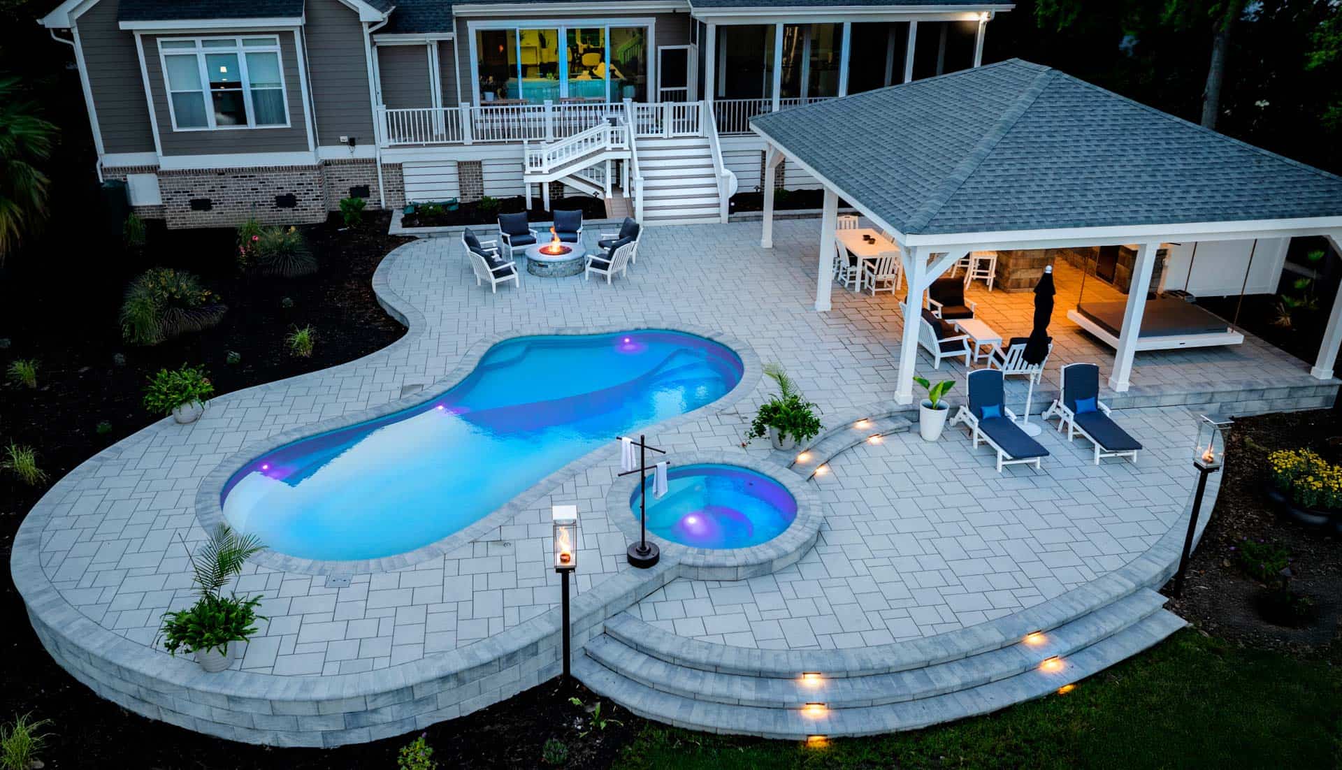 Swimming Pool surrounded by custom harscape with stairs and hot tub. 