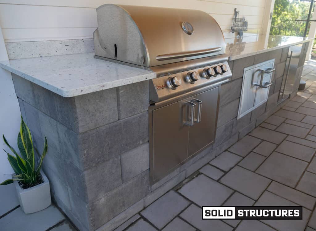 Outdoor Kitchen with Granite Countertops (color As Shown), Firemagic and Blaze Appliances, and Built-in Sink with Faucet.