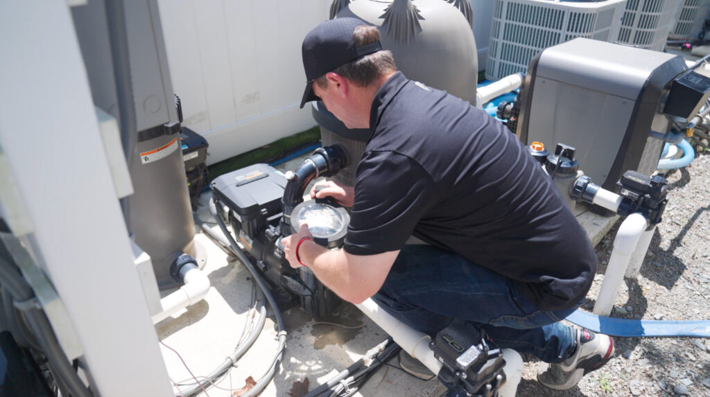 Pool Maintanence Blog Image - Solid Structures Man Conducting Maintenance on Swimming Pool Equipment