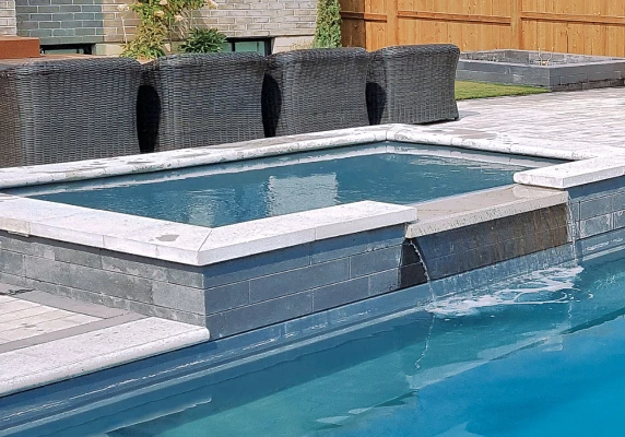 Mercury Tanning Ledge with Water Feature and swimming pool.