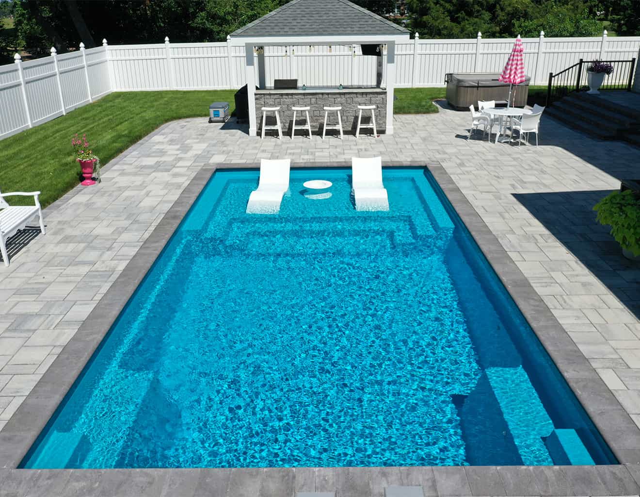 Completed fiberglass swimming pool with a built-in tanning ledge.